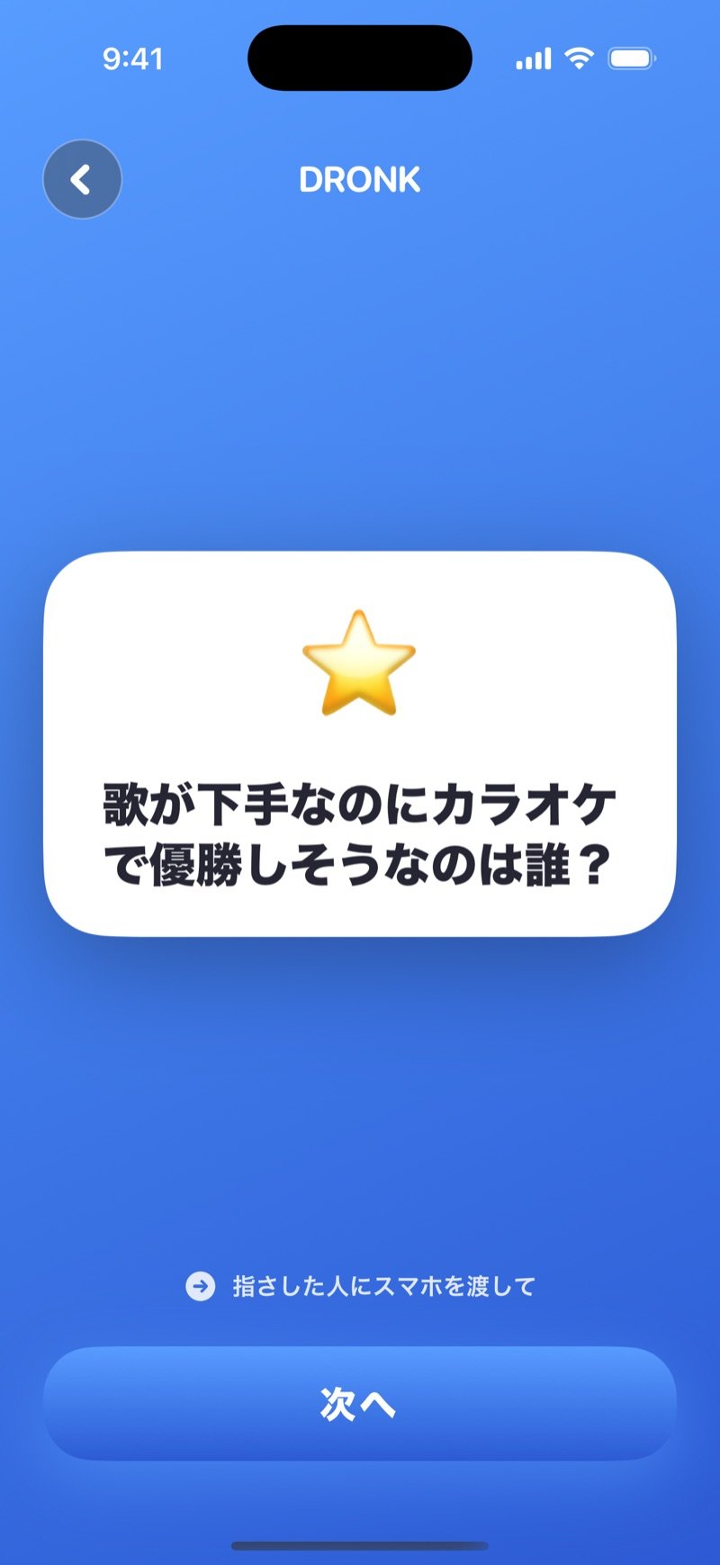 Dronkアプリの誰が一番：白い質問カードにWho's most likely to win karaoke night, without being able to sing?（歌えないのにカラオケの夜で優勝しそうなのは誰？）、その下にヒントのPass the phone to whoever you point atとNextボタン（英語版の画面）
