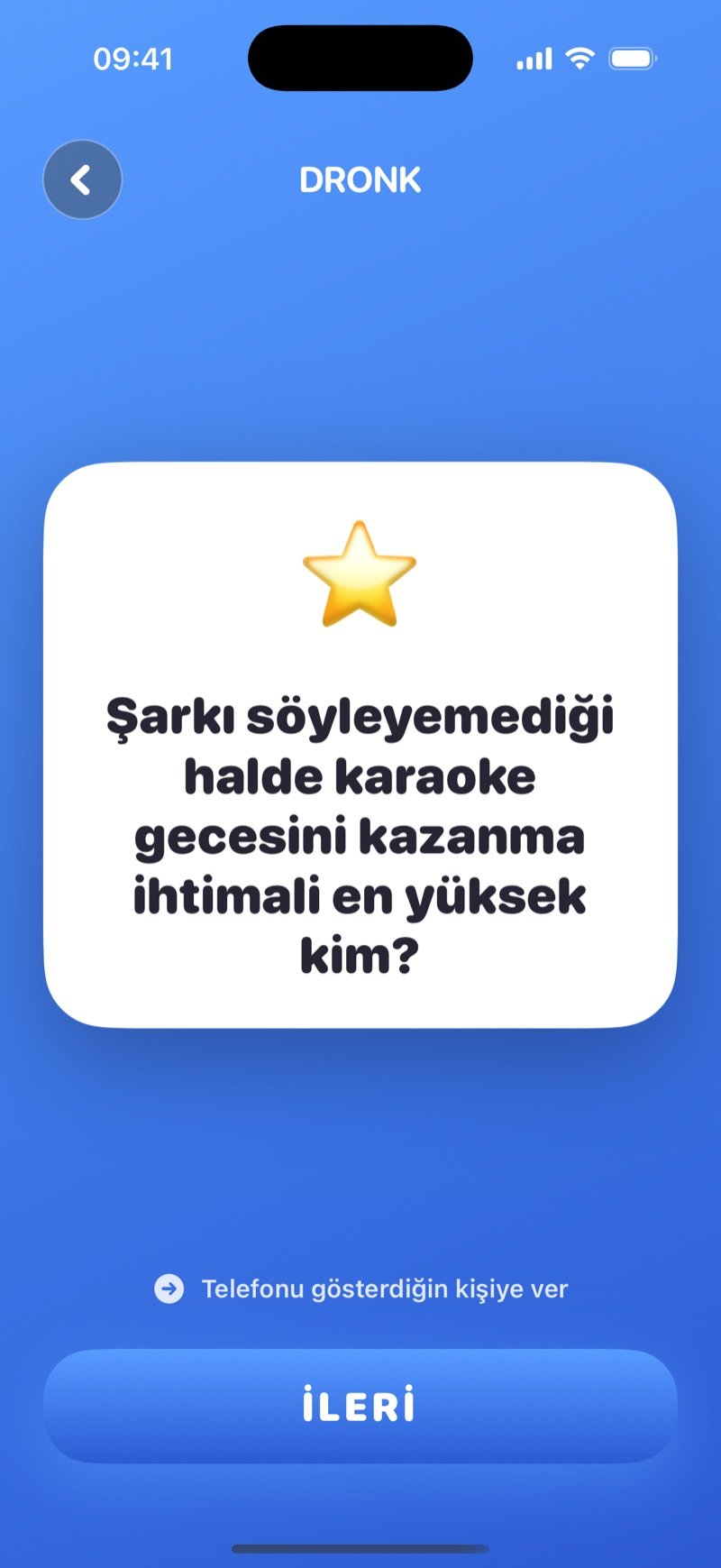 Dronk uygulamasında En Çok Kim: beyaz bir soru kartı, Telefonu gösterdiğin kişiye ver ipucu ve İleri düğmesi