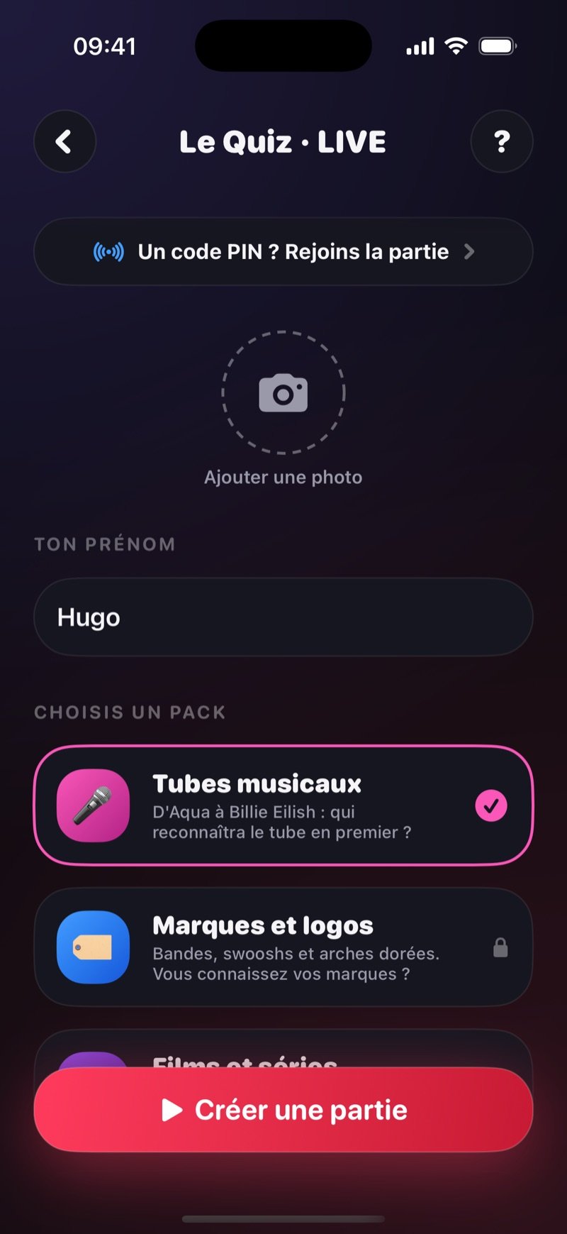Écran de création du Quiz LIVE dans Dronk : une ligne Got a game pin? Join the game, un cercle Add photo, Your name réglé sur Jacob, Pick a pack avec Music Hits sélectionné et Brands & Logos avec un cadenas, et un bouton Create game (capture de la version anglaise)